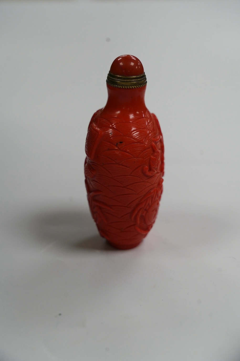 A Chinese coral coloured glass 'crabs' snuff bottle, 8.2cm high. Condition - good